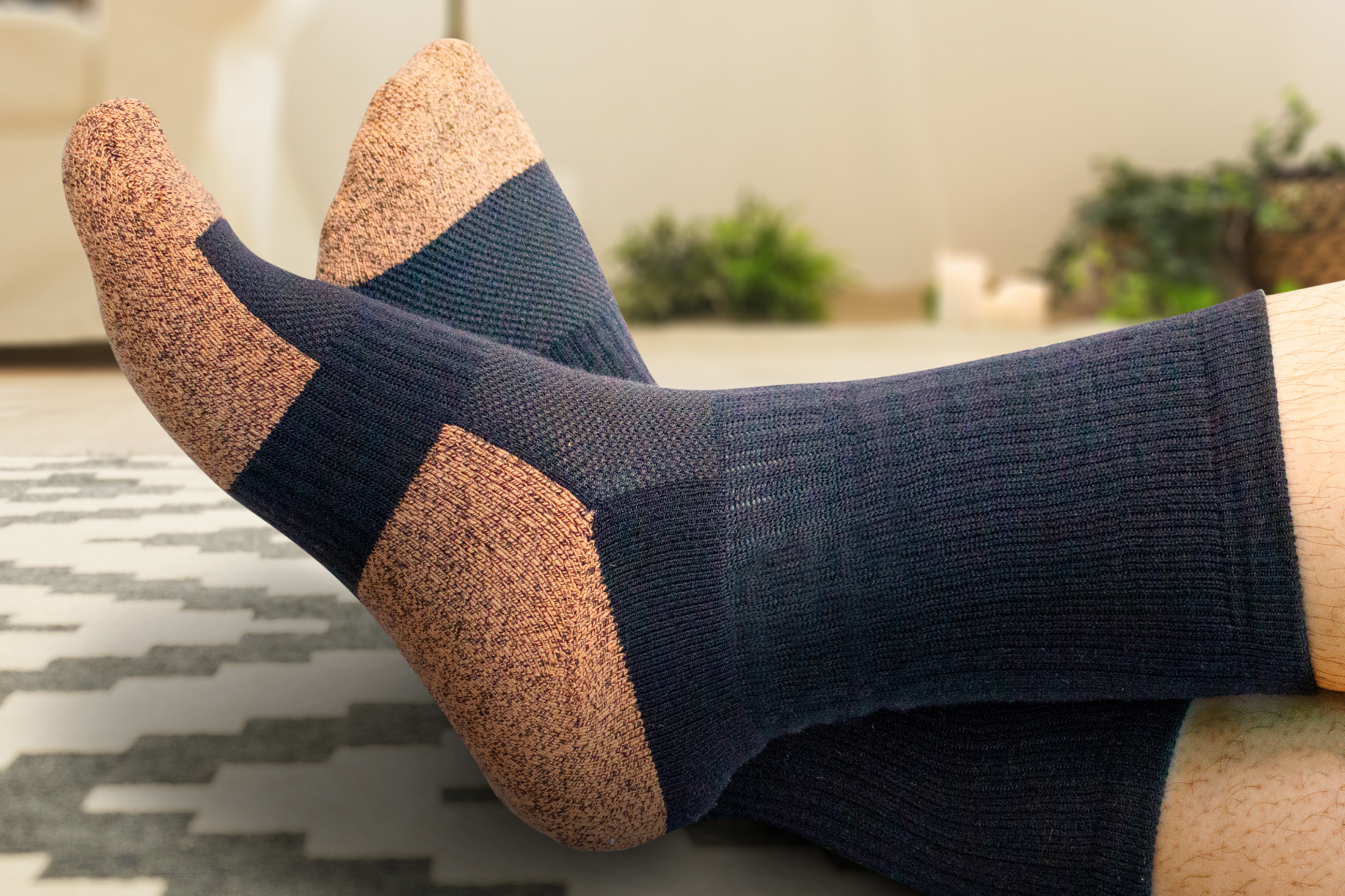 Copper Cloud Crew Length Unisex Black Socks A pair of feet wearing Copper Cloud Crew Length Unisex black socks indoors on a tan and dark gray rug