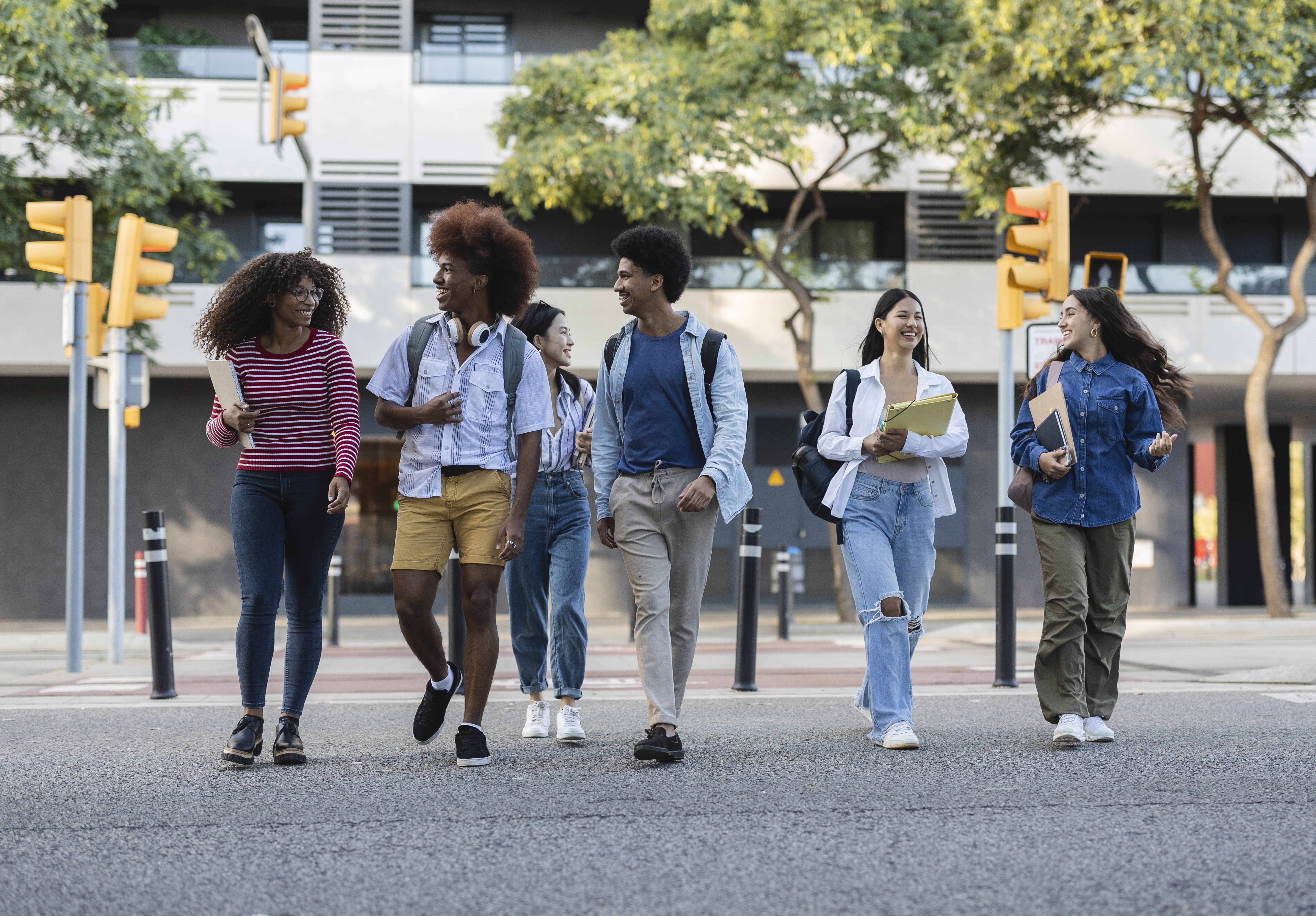 Group of college students walking down a street.