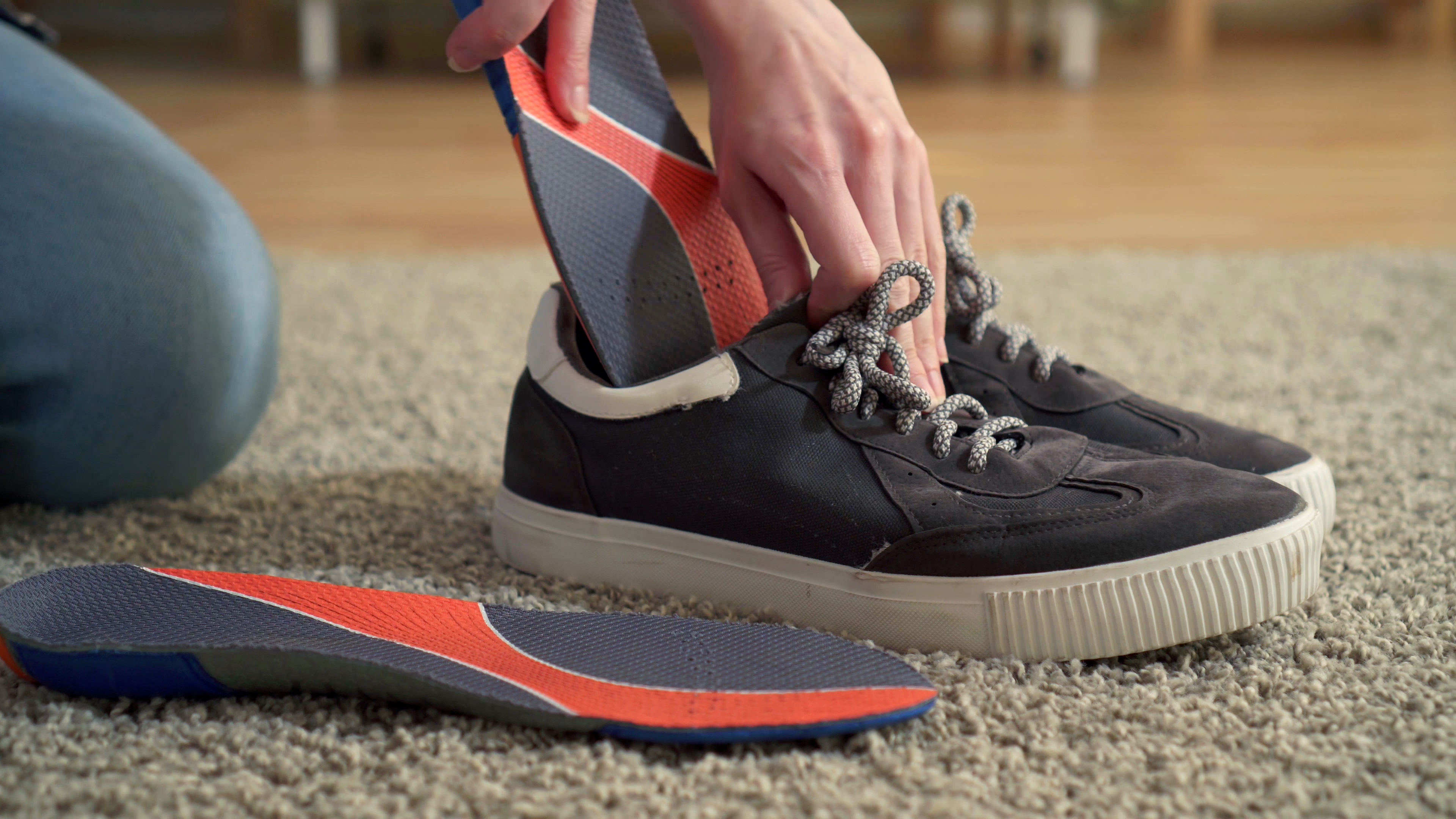 Close up of person putting orthotic insert in shoes