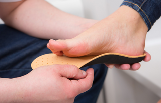 closeup of woman's foot trying on orthotic insert